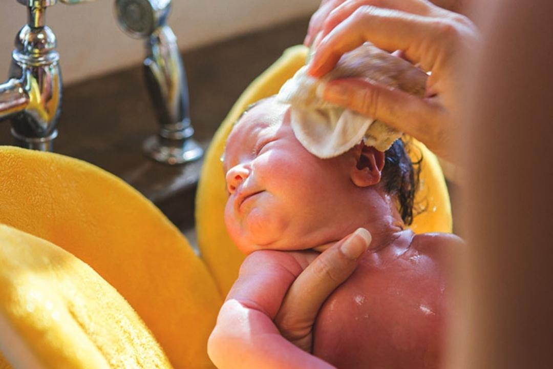 newborn baby washing face